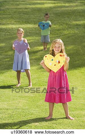 Stock Photo - Young children holding paper hearts. Fotosearch