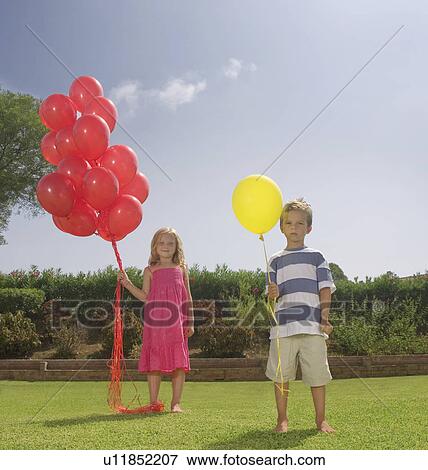 Stock Photo - Young children holding red balloons. Fotosearch
