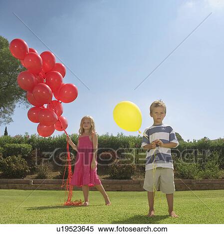 Stock Photography - Young children holding red balloons. Fotosearch
