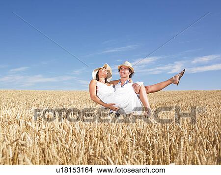 Picture - young couple in wheat field. Fotosearch
