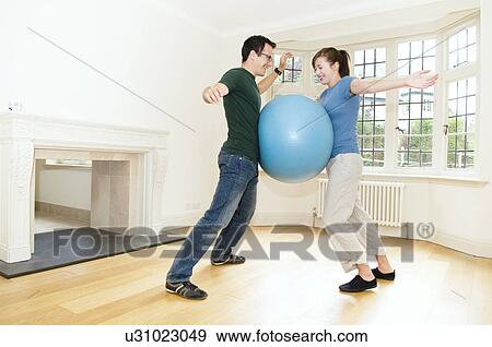 Young couple play with an exercise ball View Large Photo Image Stock Photo - Young couple play with an exercise ball. Fotosearch