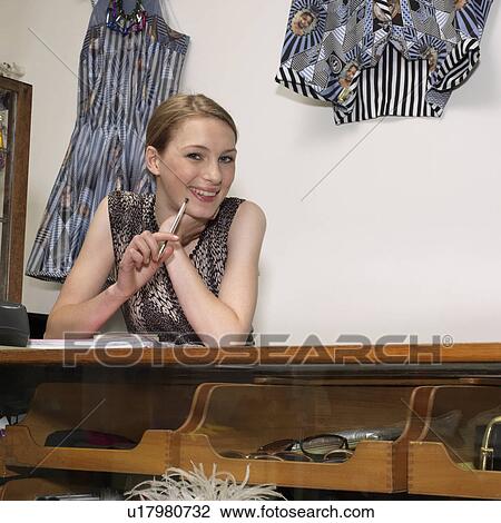 Stock Image - Young female shop assistant. Fotosearch