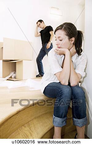 Stock Photograph - Young female sitting with head in hands.. Fotosearch