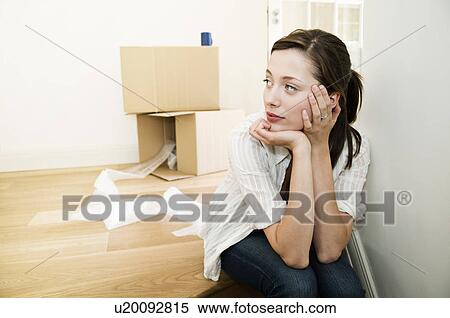 Stock Photography - Young female sitting with head in hands.. Fotosearch