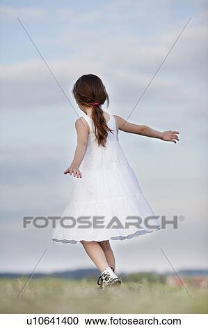 young girl dancing in the grass View Large Photo Image Stock Image - young girl dancing in the grass. Fotosearch
