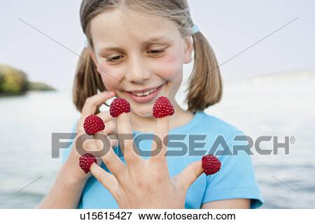 Stock Photo - Young Girl Eating Raspberries. Fotosearch