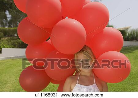 Young girl holding bunch of red balloons View Large Photo Image Stock Image - Young girl holding bunch of red balloons. Fotosearch