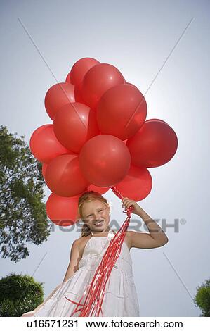 Young girl holding bunch of red balloons View Large Photo Image Stock Image - Young girl holding bunch of red balloons. Fotosearch