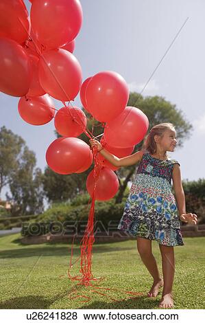 Stock Photo - Young girl holding bunch of red balloons. Fotosearch