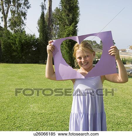 Stock Photography - Young girl holding paper heart frame. Fotosearch