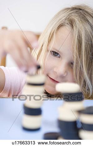 Young girl making tower out of dominoes View Large Photo Image Stock Image - Young girl making tower out of dominoes. Fotosearch
