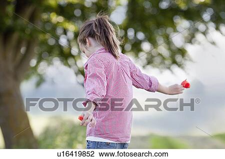 Stock Image - young girl playing with flowers. Fotosearch