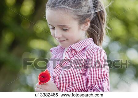 Stock Photography - young girl playing with flowers. Fotosearch