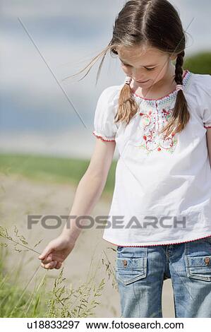 Stock Photo - young girl playing with grass. Fotosearch