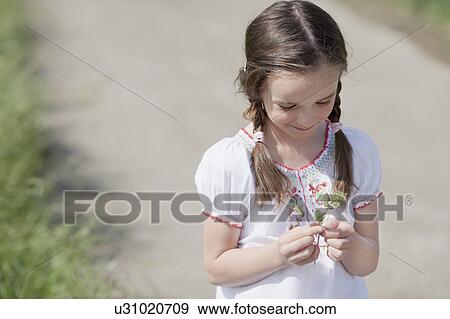 Stock Photo - young girl playing with grass. Fotosearch