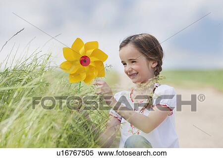 young girl playing with toy windmill View Large Photo Image Stock Photography - young girl playing with toy windmill. Fotosearch