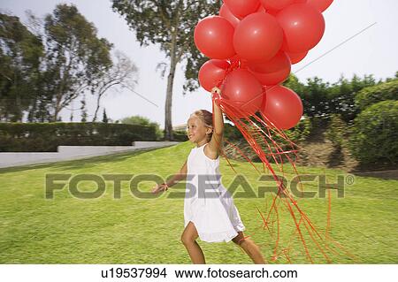 Young girl running with red balloons View Large Photo Image Picture - Young girl running with red balloons. Fotosearch