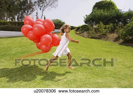 Young girl running with red balloons View Large Photo Image Stock Photograph - Young girl running with red balloons. Fotosearch