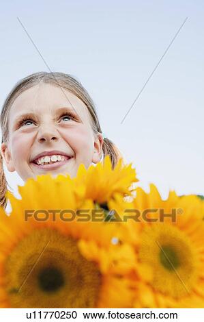 Stock Image - Young Girl With Sunflowers. Fotosearch