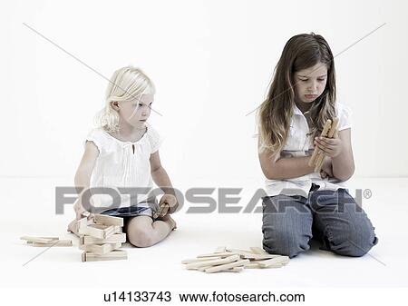Stock Image - Young girls playing with building blocks. Fotosearch