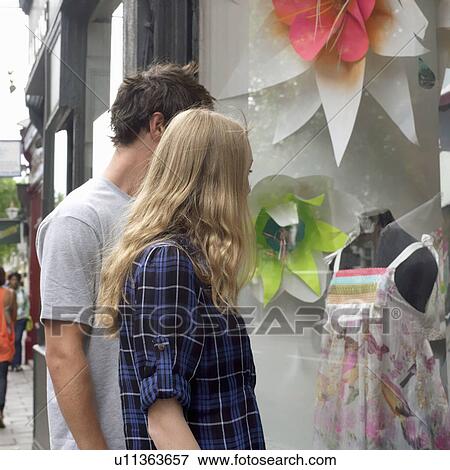 Young man and woman looking at shop wind View Large Photo Image Stock Photo - Young man and woman looking at shop wind. Fotosearch