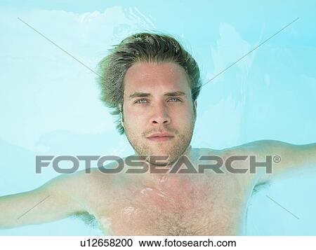 Stock Image - young man floating in water. Fotosearch