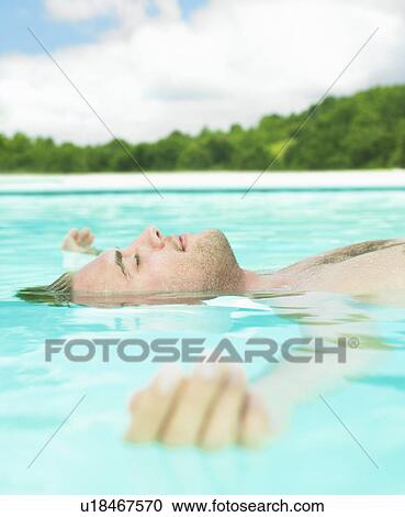 young man floating in water View Large Photo Image Stock Image - young man floating in water. Fotosearch