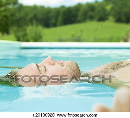 Stock Image - young man floating in water. Fotosearch