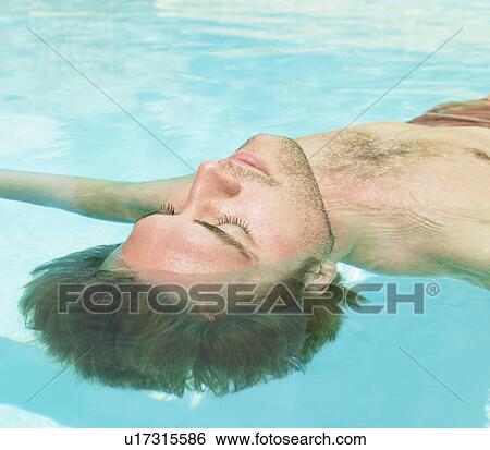 Stock Photograph - young man floating in water. Fotosearch
