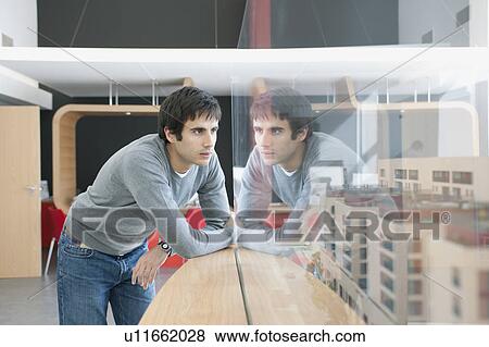 Stock Photo - young man looking at construction model. Fotosearch