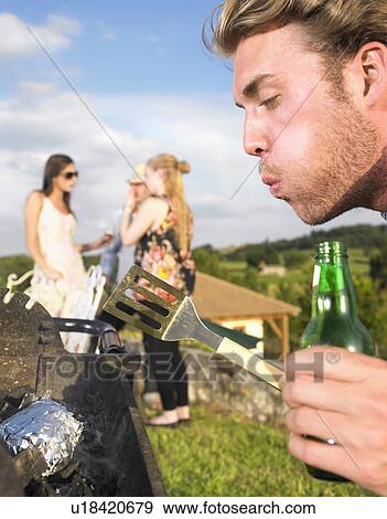 young man tending barbecue View Large Photo Image Stock Photo - young man tending barbecue. Fotosearch