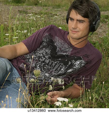 Young man with headphones in park View Large Photo Image Stock Image - Young man with headphones in park. Fotosearch
