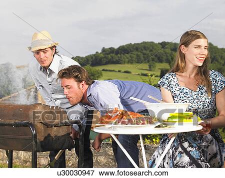 Stock Photo - young people having barbecue. Fotosearch