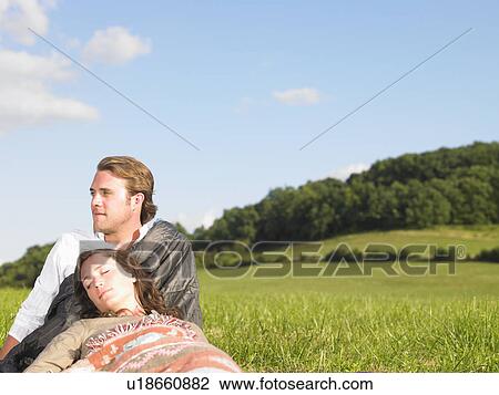 Stock Image - young people lying in field. Fotosearch