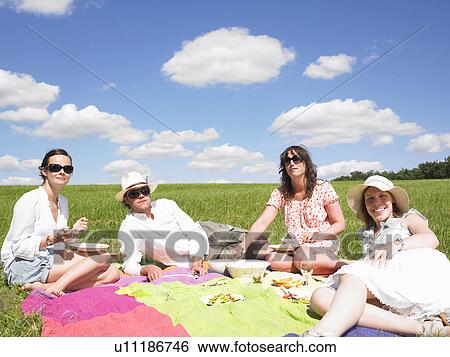 Stock Photograph - young people on blanket in field. Fotosearch