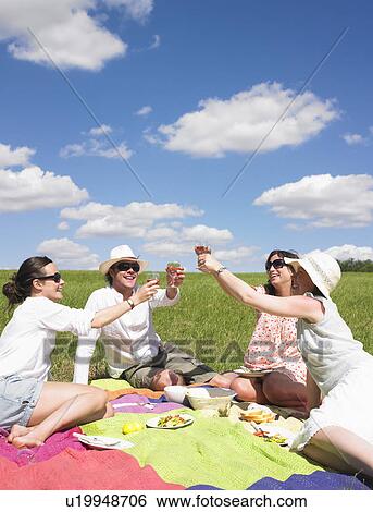 Stock Photograph - young people on blanket in field. Fotosearch
