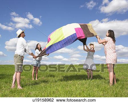 Stock Image - young people with picnic blanket. Fotosearch