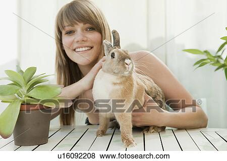 Young woman and a pet rabbit on a patio View Large Photo Image Stock Photo - Young woman and a pet rabbit on a patio. Fotosearch