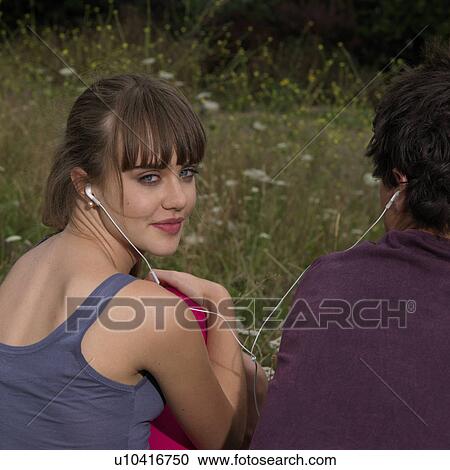 young woman and man sharing headphones View Large Photo Image Stock Image - young woman and man sharing headphones. Fotosearch