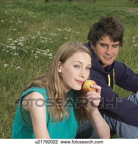 Young woman and man with an apple View Large Photo Image Stock Image - Young woman and man with an apple. Fotosearch