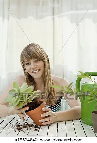 Young woman and plants on patio View Large Photo Image Stock Image - Young woman and plants on patio. Fotosearch