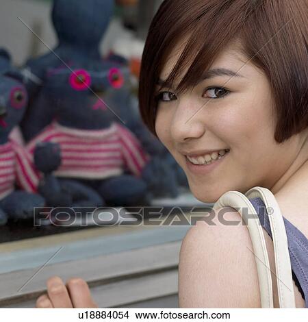 young woman at shop window smiling View Large Photo Image Picture - young woman at shop window smiling. Fotosearch