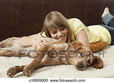 Stock Image - Young woman cuddling with her dog. Fotosearch