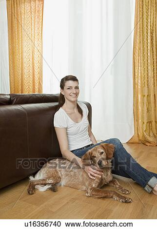 Stock Image - Young woman, dog sitting beside her. Fotosearch