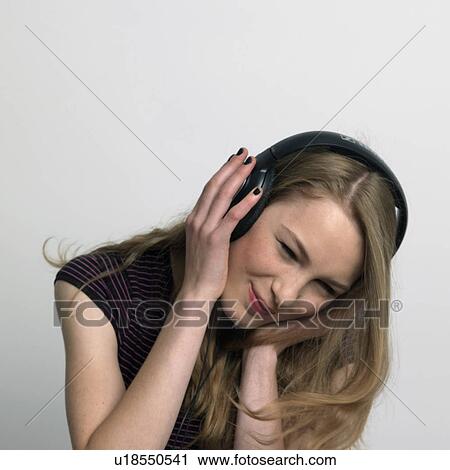 Stock Image - young woman listening to music. Fotosearch