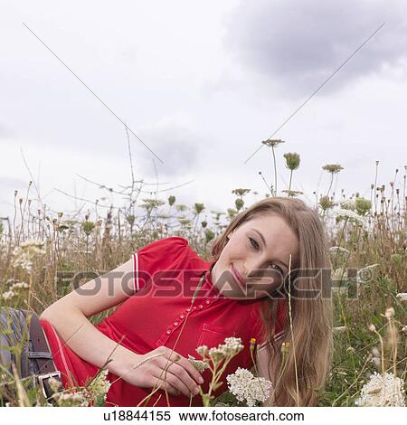 Young woman lying in high grass and flower View Large Photo Image Stock Photography - Young woman lying in high grass and flower. Fotosearch