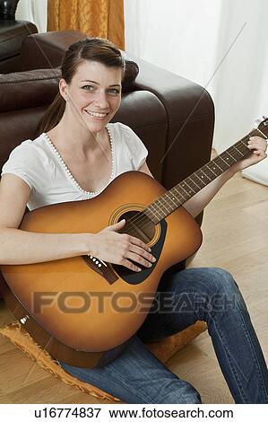 Stock Photo - Young woman playing the guitar. Fotosearch