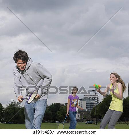 young woman shoots water pistol at friend View Large Photo Image Stock Photo - young woman shoots water pistol at friend. Fotosearch