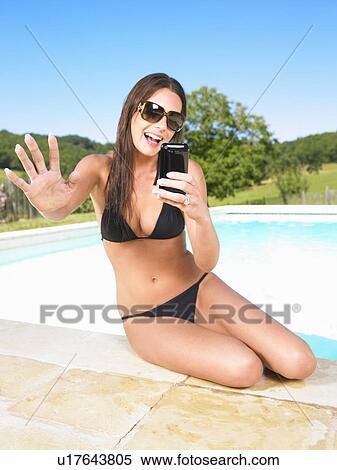 young woman using phone by pool View Large Photo Image Stock Photography - young woman using phone by pool. Fotosearch