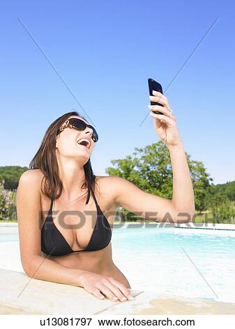 young woman using phone in pool View Large Photo Image Stock Photo - young woman using phone in pool. Fotosearch